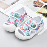 Colorful children's shoes with floral pattern on a light gray surface