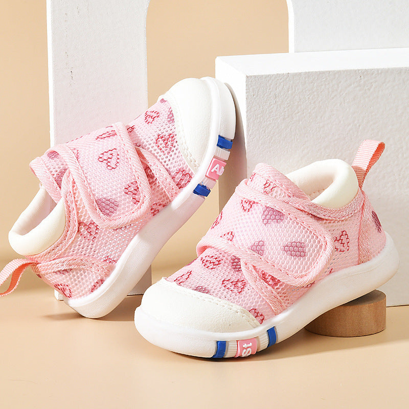 Pink children's sneakers with white soles on a beige background