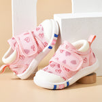 Pink children's sneakers with white soles on a beige background