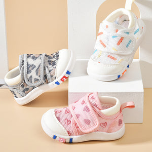 Three pairs of children's shoes in different colors on a beige background