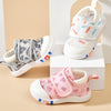 Three pairs of children's shoes in different colors on a beige background