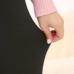 Hand holding a black fabric against a beige background