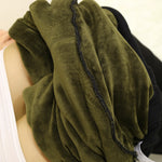Green towel or fabric held by a person with a neutral background