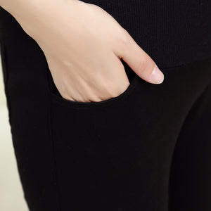 Person wearing black pants with a hand in the pocket