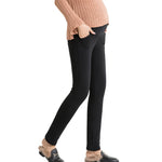 Person wearing black leggings and a beige sweater on a white background